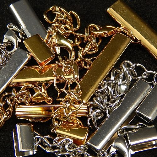 Klemme mit Verlaengerungskette und Karabiner gold und rhodiniert